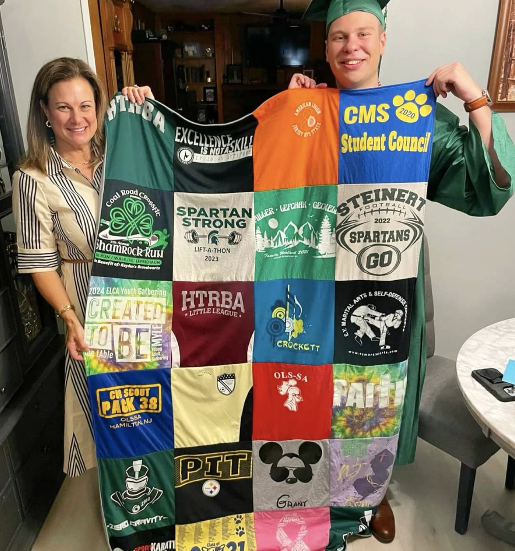 Mom and son in graduation cap and gown holding a Project Repat custom t-shirt memory quilt